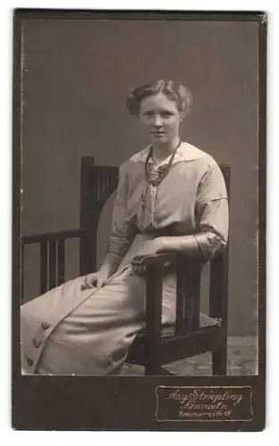 Fotografie Aug. Striepling, Hameln, Emmernstr. 18, Portrait modisch gekleidete Dame mit Halskette auf Stuhl sitzend