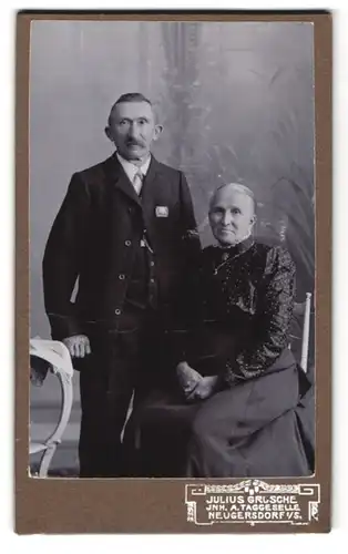 Fotografie Julius Grusche, Neugersdorf, Betagtes Ehepaar in Feiertagskleidung