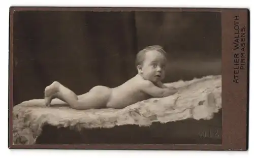 Fotografie Walloth, Pirmasens, Nackter erstaunter Säugling auf Fell