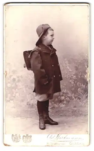 Fotografie Ad. Hartmann, Dessau, Portrait kleiner Junge mit Hut und Ranzen