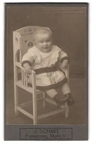 Fotografie J. Schmit, Frankenberg, Markt 12, Portrait neidliches Baby im hübschen Kleid auf Stuhl sitzend