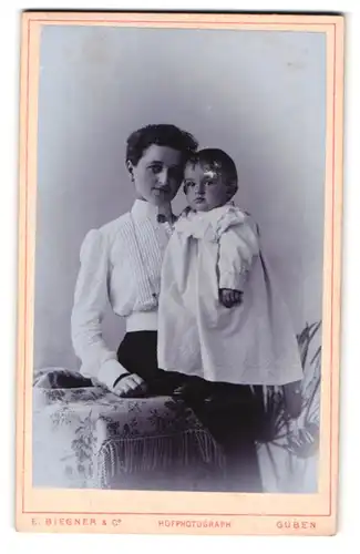 Fotografie E. Biegner & Co., Guben, Am Wilhelmsplatz 9, Portrait bürgerliche Dame mit Kleinkind auf dem Arm