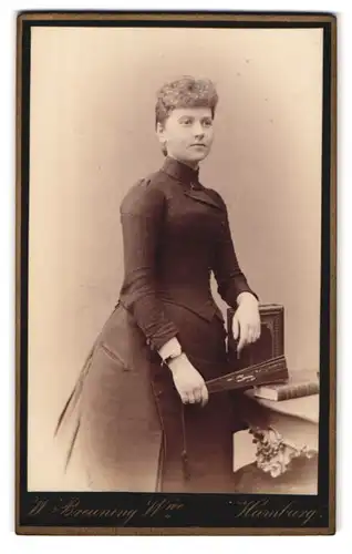 Fotografie W. Breuning Witwe, Hamburg, Berg-Strasse 26, Portrait bürgerliche Dame mit Fächer an Tisch gelehnt