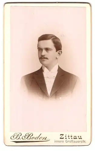 Fotografie B. Boden, Zittau, Innere Grottauerstrasse, Portrait eleganter Herr mit Fliege und Schnurrbart