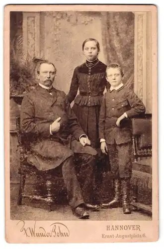 Fotografie F. Wunder Sohn, Hannover, Ernst-Augustplatz 6, Vater mit Schnauzbart sitzend neben Tochter und Sohn