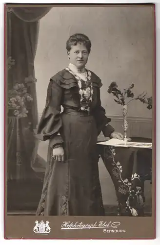 Fotografie Ernst Ebel, Bernburg, Wilhelmstrasse 27, Portrait bürgerliche Dame mit Zeitung an Tisch gelehnt