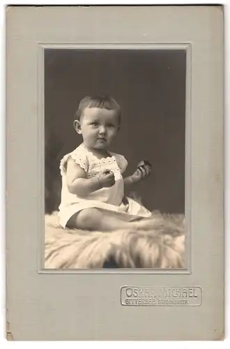 Fotografie Oskar Michael, Gittersee, Dresdenerstrasse, Portrait niedliches Kleinkind im weissen Hemd auf Fell sitzend