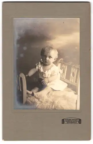 Fotografie Richard Krasselt, Borna, Bahnhofstrasse 32, Portrait niedliches Kleinkind im weissen Hemd auf Fell sitzend