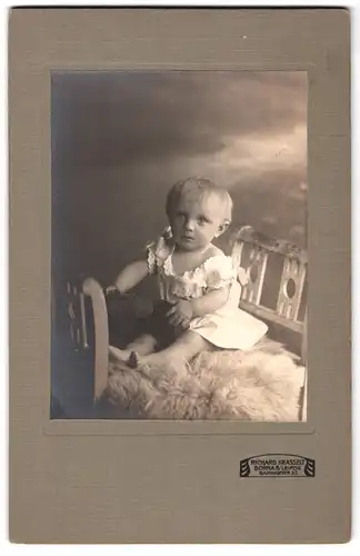 Fotografie Richard Krasselt, Borna, Bahnhofstrasse 32, Portrait niedliches Kleinkind im weissen Hemd auf Fell sitzend