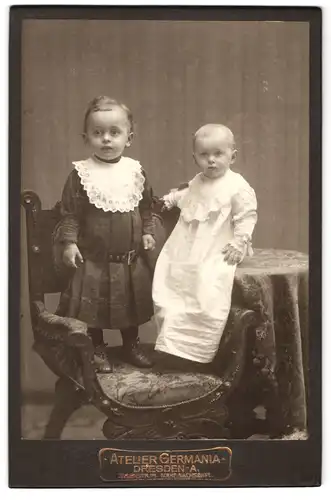 Fotografie Atelier Germania, Dresden, Elisenstrasse 71, Geschwisterpaar stehen zusammen auf einem Stuhl