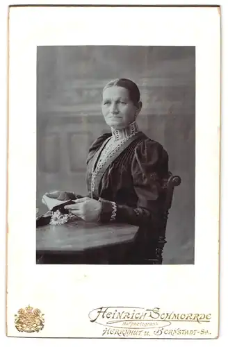 Fotografie Heinrich Schmorde, Herrnhut i. Sa., Bürgerliche in elegantem Kleid mit Buch