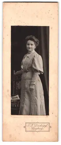 Fotografie T. J. Dickopf, Siegburg, Frau im hellen Kleid steht elegant an einem Stuhl