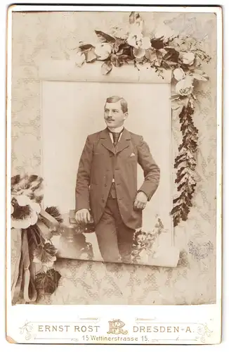 Fotografie Ernst Rost, Dresden-A., Wettinerstrasse 15, Mann im Anzug und Lächeln auf den Lippen lehnt sich an