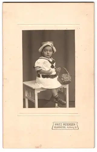 Fotografie Fritz Petersen, Neumünster, Kuhberg 18, Portrait kleines Mädchen im Matrosenkleid mit Korb