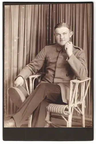 Fotografie unbekannter Fotograf und Ort, Portrait Soldat in Uniform auf Stuhl sitzend