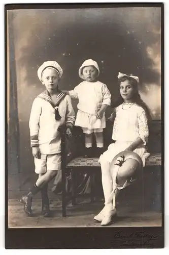 Fotografie ERnst Freitag, Finsterwalde, Portrait Kinderpaar mit Kleinkind in modischer Kleidung mit Hut