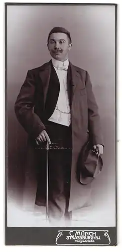 Fotografie C. Münch, Strassburg i. Els., Königsbrücke, Junger Mann in schickem Anzug und Hut in der Hand