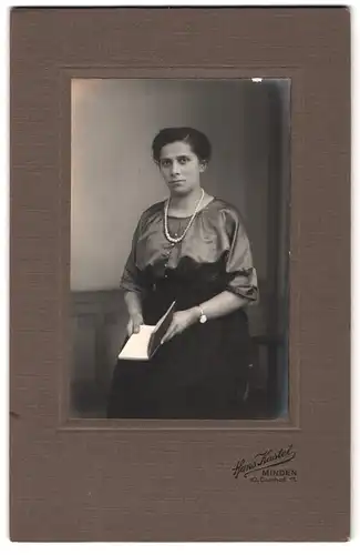 Fotografie Hans Kastel, Minden, Kl. Domhof 11., Junge Frau in grauer Bluse mit Buch und Armbanduhr