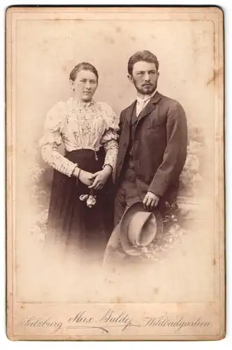 Fotografie Max Balder, Salzburg, Portrait bürgerliches Paar in hübscher Kleidung mit Hut