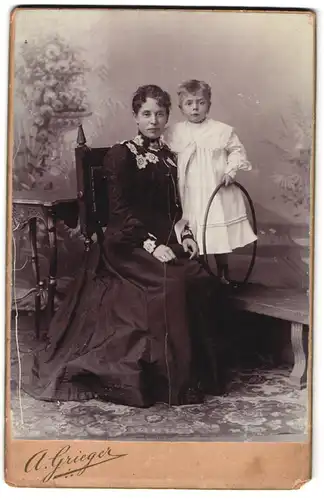 Fotografie A. Grieger, Berlin, Friedens-Strasse 8, Mutter in schwarzem Kleid mit ihrem Kind