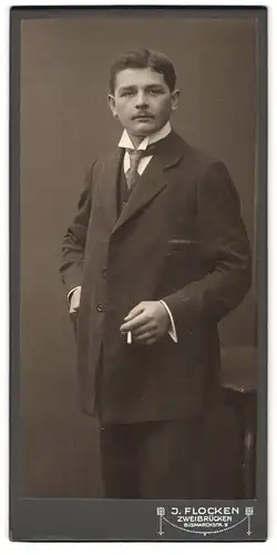 Fotografie J. Flocken, Zweibrücken, Bismarckstrasse 9, Portrait junger Herr im eleganten Anzug mit Zigarette