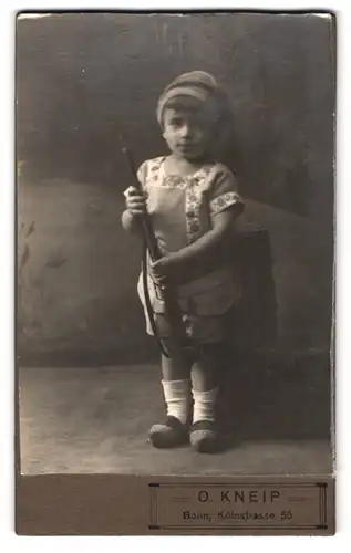 Fotografie O. Kneip, Bonn, Kölnstrasse 50, Portrait kleiner Junge mit Holzschuhe und Spielzeuggewehr