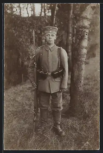 Foto-AK junger Soldat der Infanterie in Feldgrau Uniform mit Aufgepflanztme Bajonett, Ausmarschgepäck