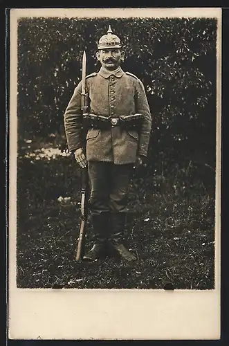 Foto-AK Soldat Wilhelm Berker in Feldgrau Uniform mit Pickelhaube Preussen, Ersatz-Bajonett auf Gewehr
