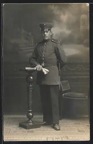 Foto-AK Soldat in Uniform mit Bajonett vor einer Studiokulisse