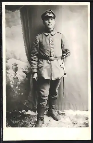 Foto-AK Uffz. in Feldgrau Uniform mit Bajonett und Portepee vor einer Studiokulisse