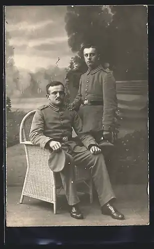 Foto-AK zwei Soldaten in Feldgrau Garde Uniform mit Krätzchen vor einer Studiokulisse