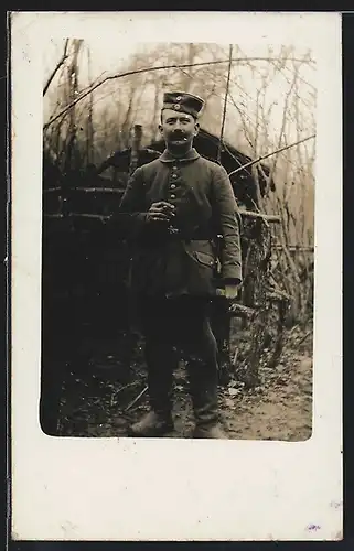 Foto-AK Soldat in Feldgrau Uniform mit Bajonett und Krätzchen im Felde