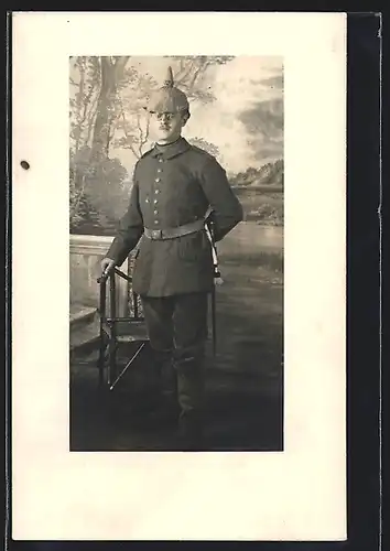 Foto-AK Soldat in Feldgrau Uniform mit Pickelhaube Tarnbezug und Bajonett samt Portepee
