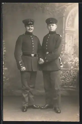 Foto-AK zwei Soldaten in Uniform mit Bajonett vor einer Studiokulisse