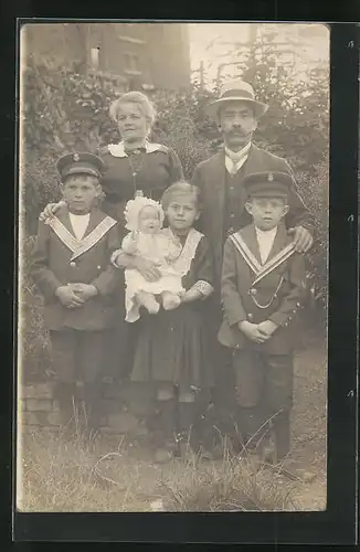 Foto-AK Familienfoto in Sonntagskleidung mit einer Puppe