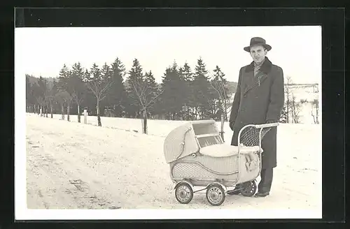 AK Mann schiebt einen Kinderwagen über die Landstrasse