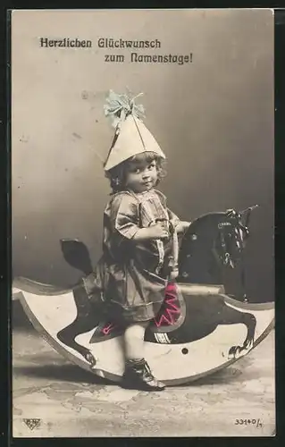 AK Kleines Mädchen mit Partyhut auf einem Schaukelpferd