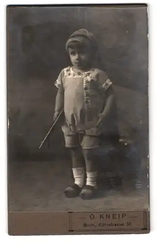 Fotografie O. Kneip, Bonn, Kölnstrasse 50, Portrait kleiner Junge mit Spielzeug-Gewehr untern Arm