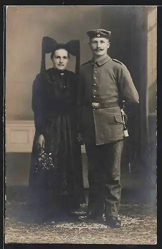 Foto-AK Soldat in Feldgrau Uniform mit Bajonett nebst seiner Frau in Markgräfler Tracht, Kriegsausmarsch