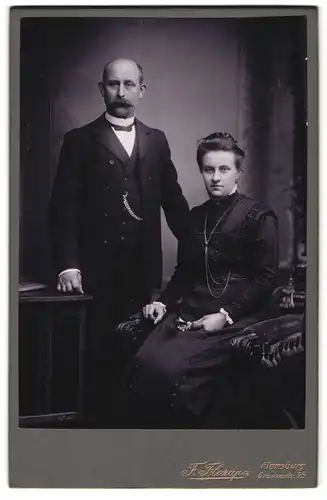 Fotografie F. Flarup, Flensburg, Grossestrasse 75, Portrait bürgerliches Paar in eleganter Kleidung mit Blume