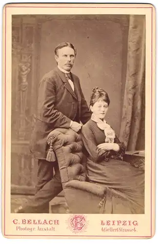 Fotografie C. Bellach, Leipzig, Gellert-Strasse 4, Portrait junges Paar in hübscher Kleidung am Sessel