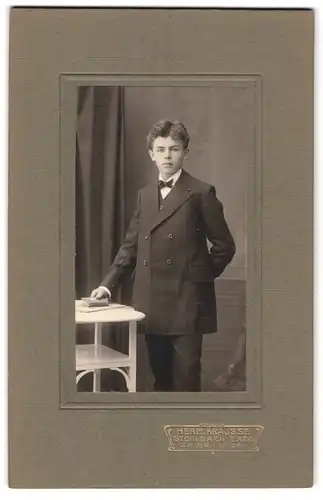 Fotografie Herm. Krausse, Steinbach / Erzg., Portrait junger Mann in eleganter Kleidung mit Buch