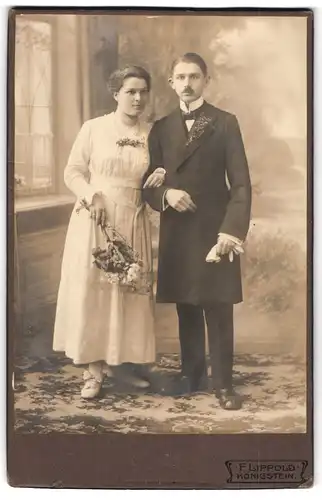Fotografie F. Lippold, Königstein, Portrait bürgerliches Paar in hübscher Kleidung mit Blumen