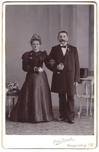 Fotografie Julius Grusche, Neugersdorf i / S., Portrait bürgerliches Paar in hübscher Kleidung mit Buch