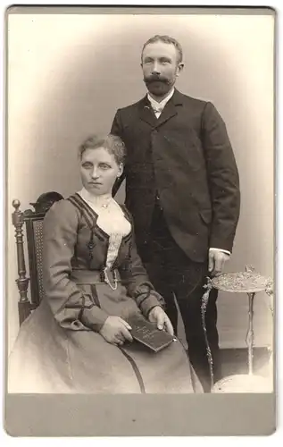 Fotografie unbekannter Fotograf und Ort, Portrait bürgerliches Paar in modischer Kleidung mit Buch
