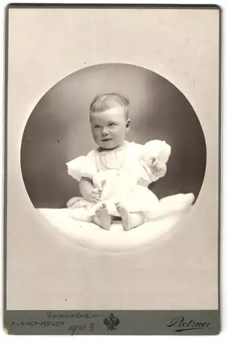 Fotografie C. Pietzner, Wien, Mariahilferstrasse 3, Kleinkind im Kleid mit Halskette sitzend
