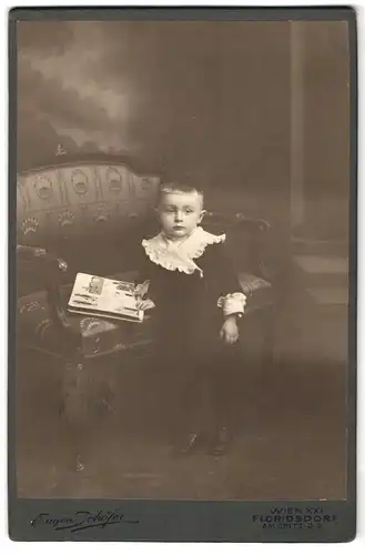 Fotografie Eugen Schöfer, Wien-Floridsdorf, Am Spitz 2-3, Portrait kleines Kind in hübscher Kleidung mit Bilderbuch