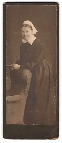 Fotografie Heinr. Stadelmann, Wernigerode, Ringstrasse 9, Portrait Ordensschwester in Kutte lehnt an Sessel
