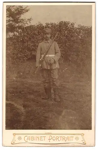 Fotografie Joh. Hass, Fockbek, Am Bahnhof, Portrait Soldat in Feldgrau Uniform mit Karabiner und Säbel