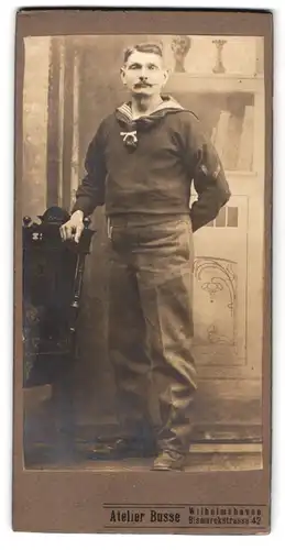 Fotografie Atelier Busse, Wilhelmshaven, Bismarckstr. 42, Portrait Matrose in Uniform mit Halstuch. Zwirbelbart